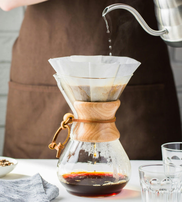 Pour over coffee being brewed in a Chemex with a paper filter, using a stainless steel gooseneck kettle