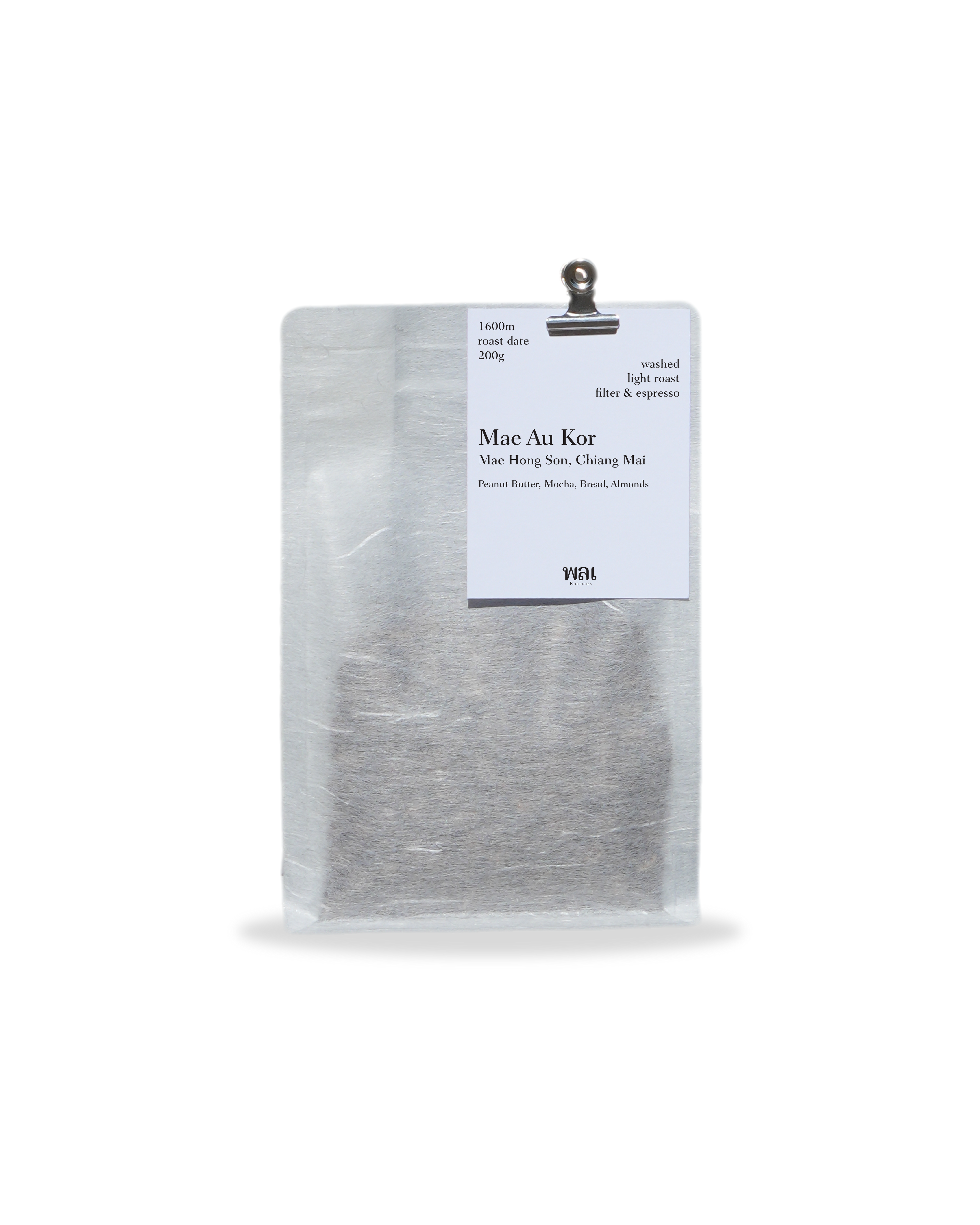 A clear/transparent/translucent bag of medium roast thai coffee beans from wai roasters with a card/postcard/polaroid clipped onto the bag roasted for filter and espresso coffee
