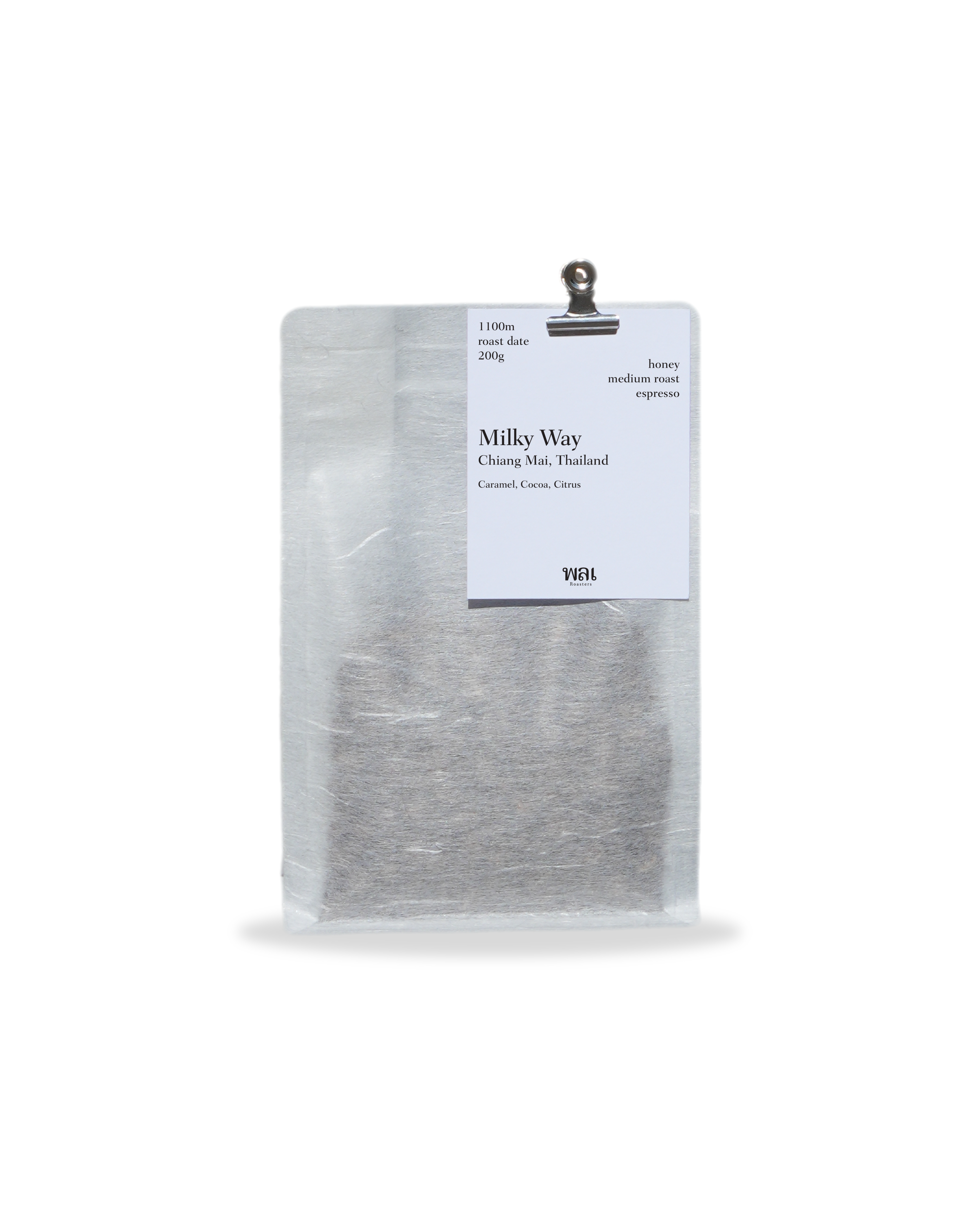 A clear/transparent/translucent bag of medium roast thai coffee beans from wai roasters with a card/postcard/polaroid clipped onto the bag roasted for espresso
